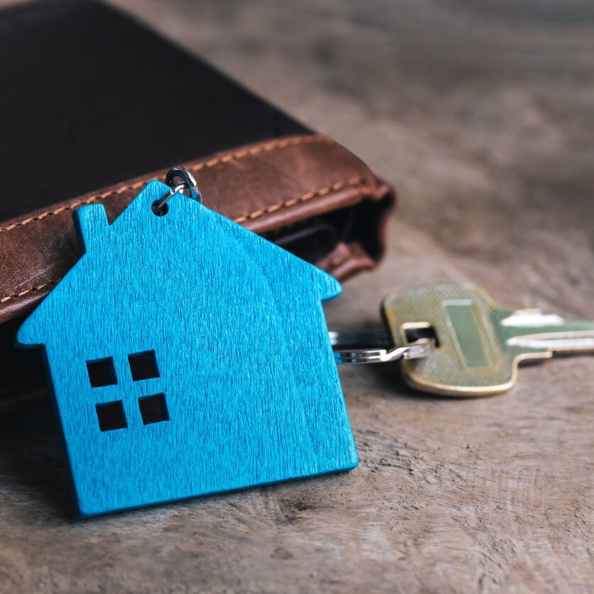 Miniature home and metal key and wallet on old wooden table. Real estate investment with new home. Miniature home and metal key and wallet on old wooden table. Real estate investment with new home.